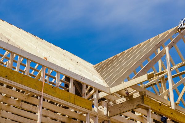 A new residential construction home framing with a roof view